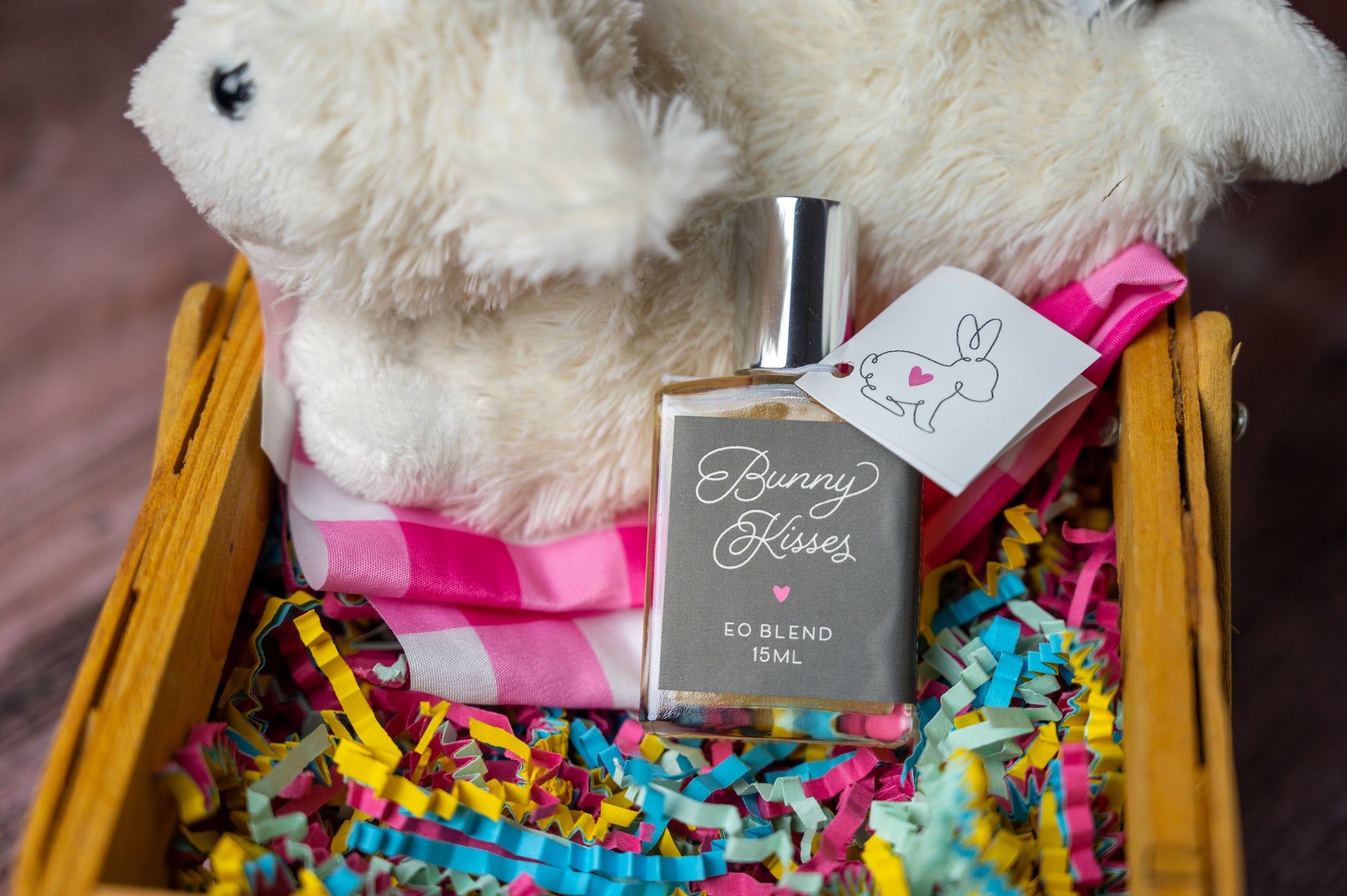 Bunny Kisses essential oil blend in a bottle in an Easter Basket with white bunny and colorful paper shreds
