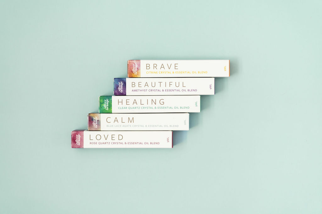 5 Boxes for Crystal Essential Oil Roller Blends on a pale aqua background in a step formation
