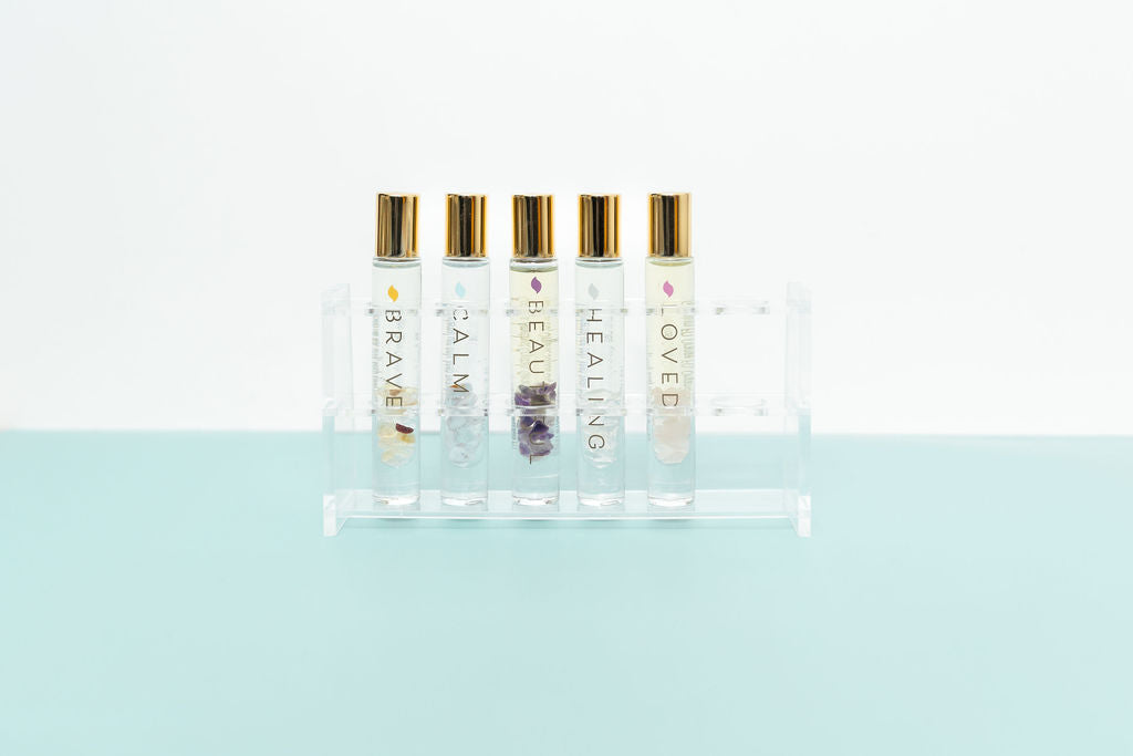 Clear Acrylic Roller Bottle Display Stand Holder with 5 crystal roller bottles on pale aqua and white backdrop