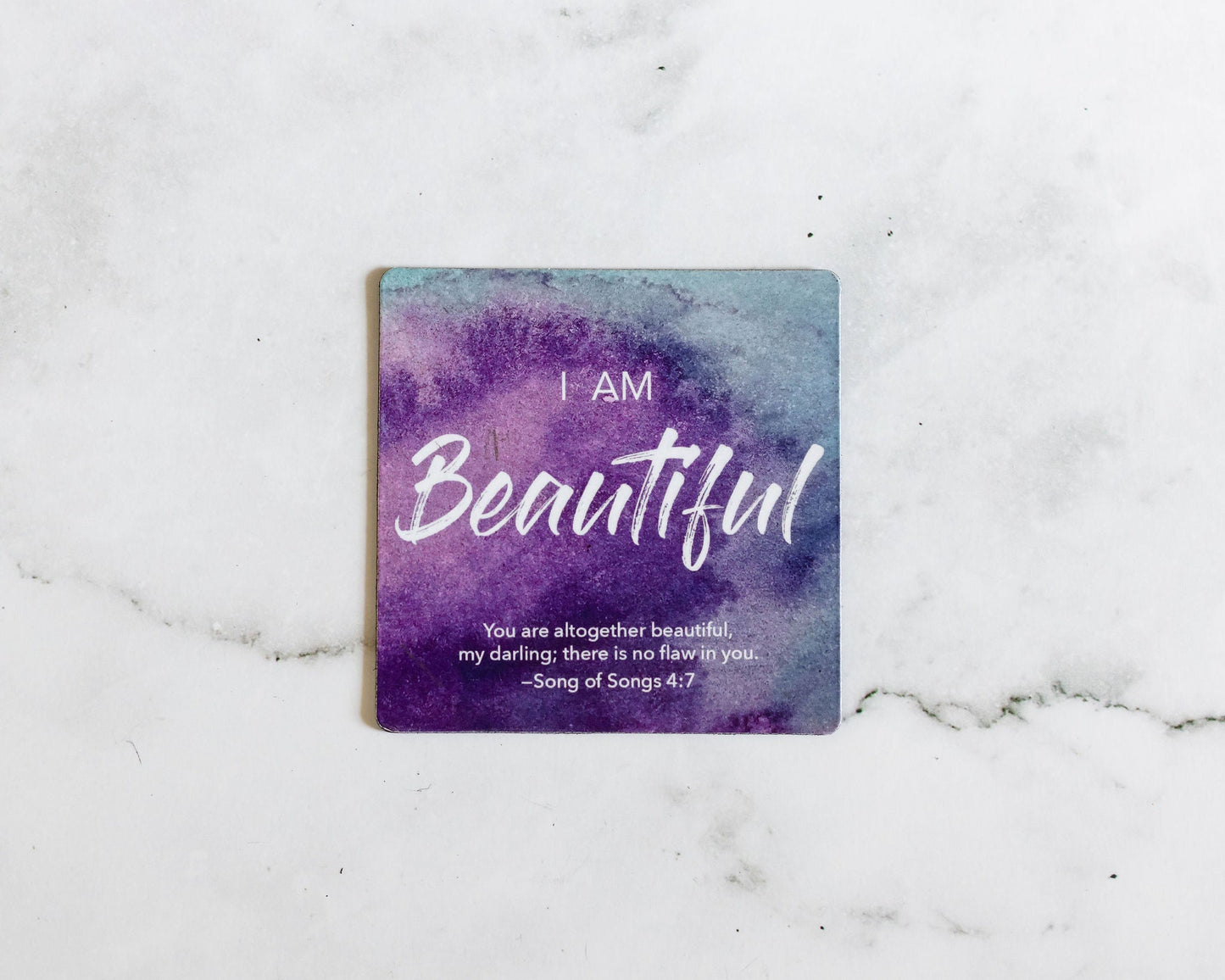 A Purple and Blue Magnet that says I Am Beautiful with a bible verse from Song of Songs 4:7 on a white marble background that says You are altogether beautiful my darling