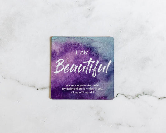 A Purple and Blue Magnet that says I Am Beautiful with a bible verse from Song of Songs 4:7 on a white marble background that says You are altogether beautiful my darling