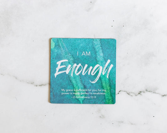 A Green and aqua magnet that says I Am Enough with a bible verse from 2 Corinthians 12:9 on a white marble background that says My grace is sufficient for you, for my power is made perfect in weakness.