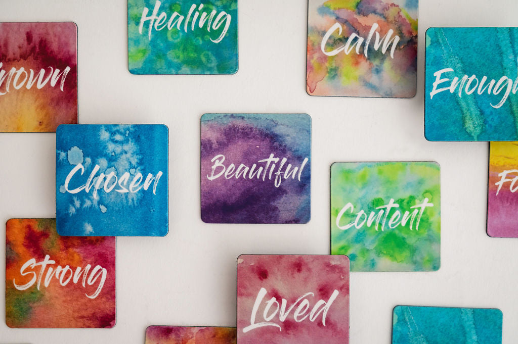 A colorful collage of several mini affirmation magnets in vivid watercolors