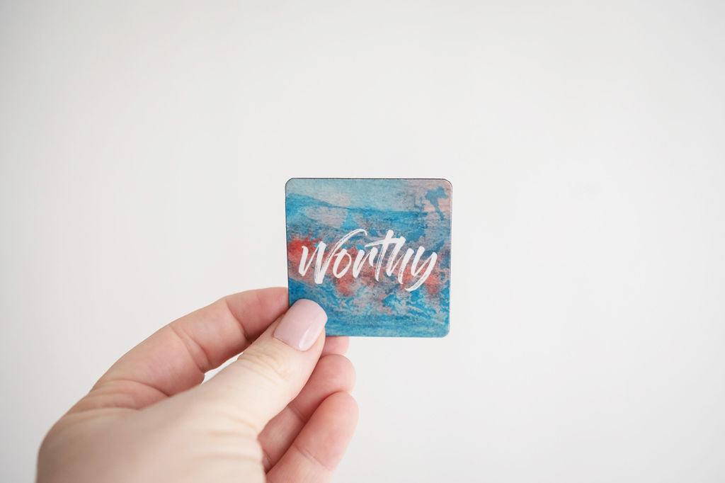 a hand holding a mini affirmation magnet that says worthy
