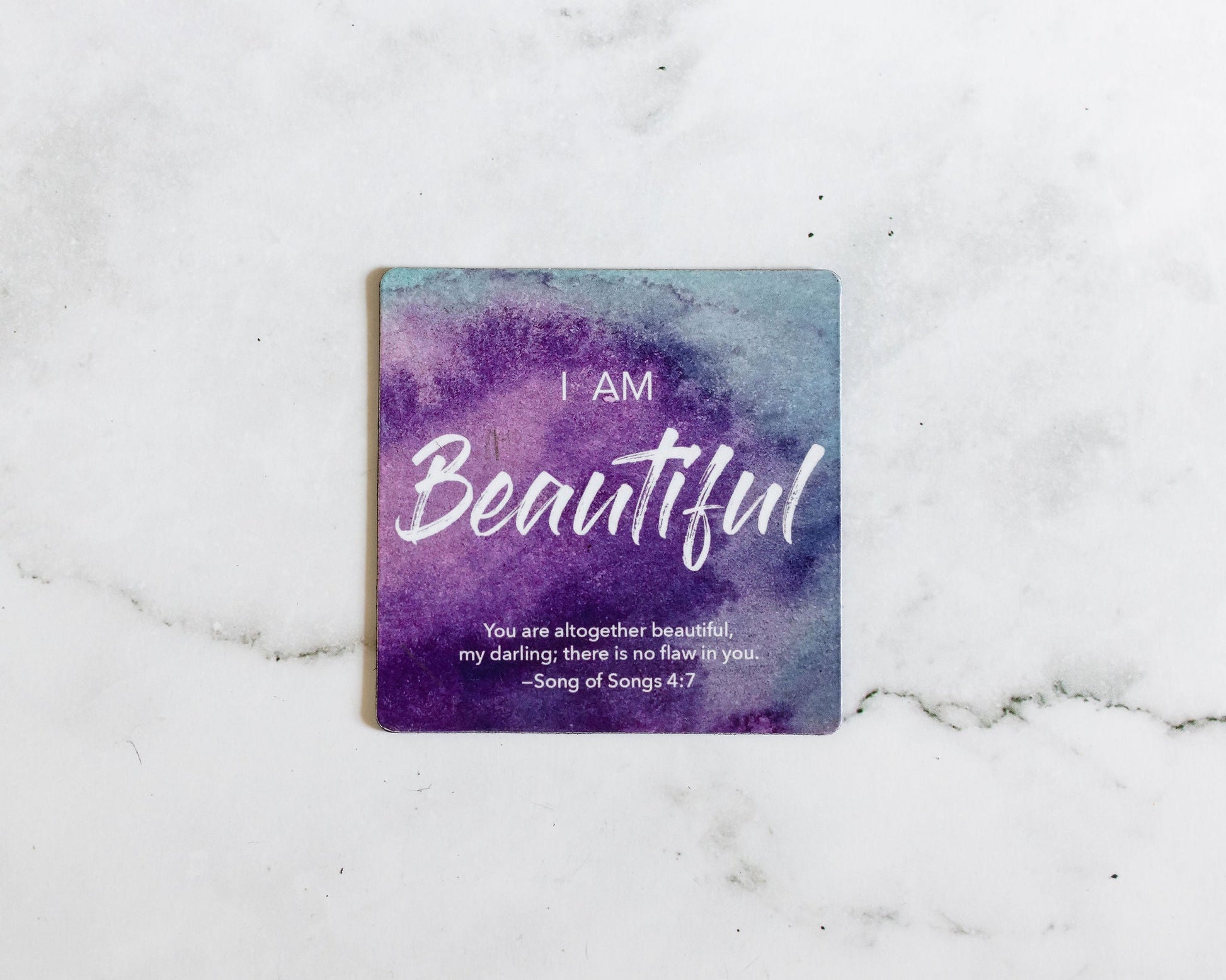 A Purple and Blue Magnet that says I Am Beautiful with a bible verse from Song of Songs 4:7 on a white marble background that says You are altogether beautiful my darling